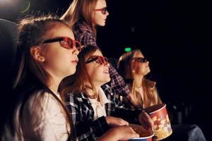 sida se. grupp av barn Sammanträde i bio och tittar på film tillsammans foto