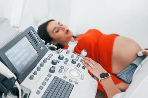ultraljud diagnostisk. gravid kvinna är i de klinik i skåp och ha hälsa kolla upp foto
