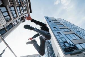 ung man håller på med parkour i de stad på dagtid. uppfattning av extrem sporter foto