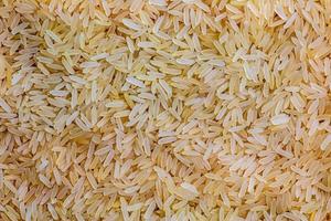 bakgrund av lång spannmål parboiled okokt ris. ris gryn som bakgrund och textur. foto