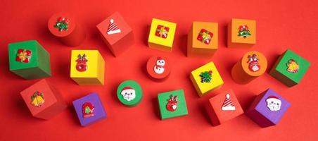 festlig baner med mjuk leksaker flerfärgad barns kuber med xmas symboler ovan på dem på röd bakgrund. foto