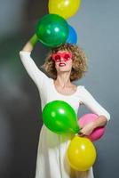 skön blond kvinna modell innehav ballonger runt om henne huvud. isolerat foto