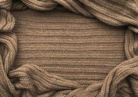 oval ram för text från brun stickat scarf eller Tröja textur, topp se. textur bakgrund av värma virkade Kläder textil. stickat tyg. foto