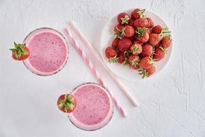 jordgubb mjölk skaka i glas med sugrör och färsk bär foto