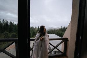 kvinna dricka te på mysigt balkong av en Land hus. foto