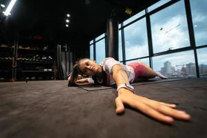 ung kvinna håller på med övningar i de Gym foto