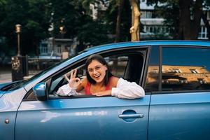 Lycklig kvinna i en bil, ser ut av de fönster. foto