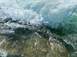 vågor, stänk av vatten på de strand på de hav på semester i en turist värma östra tropisk Land sydlig paradis tillflykt på semester. de bakgrund foto