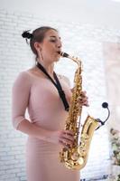 skön flicka spelar saxofon foto