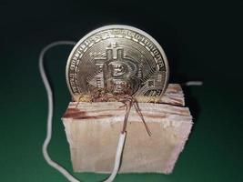 ett elektrisk tråd var hölls till de bitcoin kryptovaluta foto