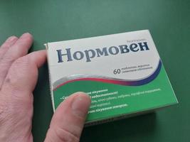 kiev, ukraina - december 10, 2022 ett äldre man innehar en paket av medicin i hans hand foto
