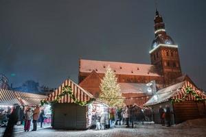 människor njut av jul marknadsföra i vinter- riga i lettland. foto