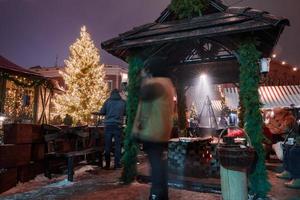 människor njut av jul marknadsföra i vinter- riga i lettland. foto