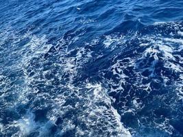 grov djup turkos och blå medelhavs hav med vit skum textur bakgrund foto