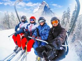 Fantastisk skön se åka skidor tillflykt i schweiz med kabel- stollift transport glad ung vänner skidåkare på åka skidor hiss foto