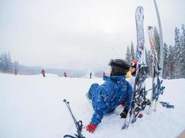 skidåkare avkopplande på solig dag på vinter- säsong med blå himmel i bakgrund foto