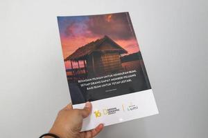 väst java, indonesien på juli 2022. en hand är innehav ett indonesiska utgåva av de nationell geografi tidskrift. foto
