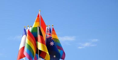 nationell flagga av Tyskland, franch, Australien och regnbåge flaggor på blå himmel och molnig bakgrund, klippning stigar. foto