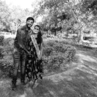 indiska par poserar för moderskap baby shoot. paret poserar i en gräsmatta med grönt gräs och kvinnan sviker sin babybula i lodhi garden i new delhi, Indien foto