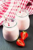 jordgubb milkshake i de glas burk på svart skiffer bakgrund foto