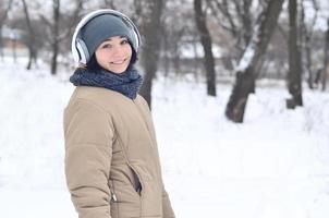vinter- porträtt av ung flicka med hörlurar foto