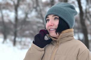 vinter- porträtt av ung flicka med smartphone foto