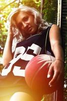 ung blond flicka med orange basketboll Framställ utomhus foto