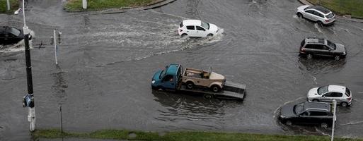 bilar är körning på en väg översvämmad foto