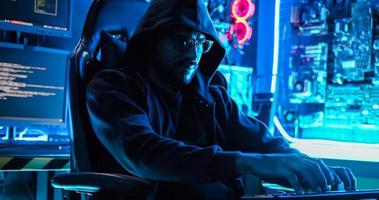 en manlig hacker är använder sig av en dator till hacka data till efterfrågan lösen från offer. foto