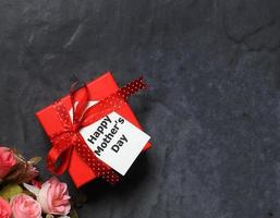 kärlek mamma - topp se av röd presentlåda, blomma och Lycklig mors dag kort på svart foto