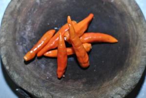 kryddad röd chili med skärande styrelse bakgrund foto