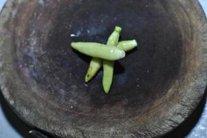 kryddad grön chili med skärande styrelse bakgrund foto