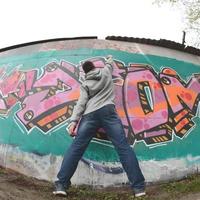 en ung kille i en grå luvtröja målarfärger graffiti i rosa och grön c foto