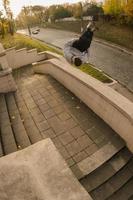 en ung kille utför en sida flip i de höst parkera. de idrottare praxis parkour, Träning i gata betingelser. de begrepp av sporter subkulturer bland ungdom foto