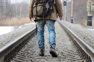 en man med en stor ryggsäck går ett huvud på de järnväg Spår duri foto