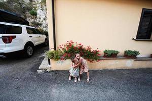 två systrar kramar nära hus på nocera umbra, stad och kommun i de provins av perugia, Italien. foto