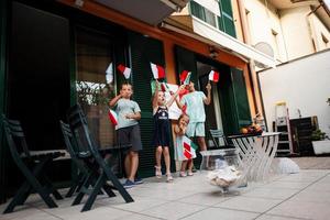 Lycklig fyra barn med italiensk flaggor fira republik dag av Italien. foto