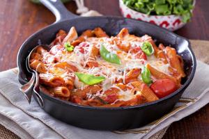 pasta baka med penne, tomater och mozarella foto