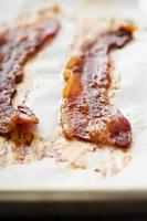 fräsande varm bacon på en bakning ark foto
