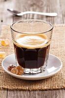 svart espresso kaffe eras i en glas foto