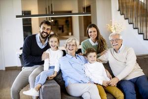 mång generation familj Sammanträde tillsammans på de soffa på Hem och tittar på TV foto