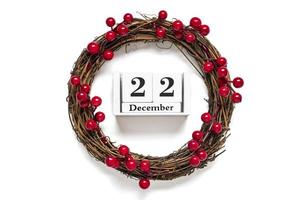 jul krans dekorerad med röd bär, trä- kalender datum 12 december isolerat på vit bakgrund begrepp av jul förberedelse, atmosfär lyckönskningar kort hand tillverkad jul krans platt lägga foto