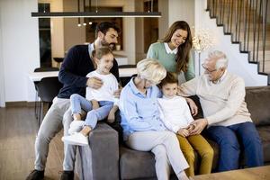 mång generation familj Sammanträde tillsammans på de soffa på Hem och tittar på TV foto
