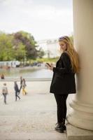 ung kvinna med mobiltelefon på gatan i Wien, Österrike foto