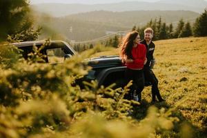 leende par framställning vandring äventyr med ryggsäckar förbi terräng fordon foto