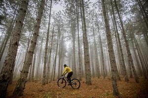 ung man cykling genom höst skog foto