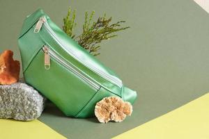 grön bälte väska tillverkad av eco läder på en sten, vegan läder från svamp mycelium begrepp foto