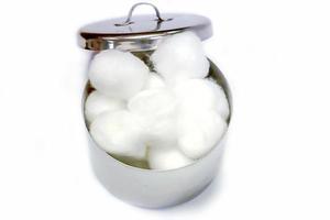 topp se av vit bomull i en medicinsk rostfri stål bomull behållare på vit bakgrund. foto