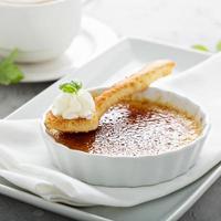 creme brulee efterrätt med en kopp av cappuccino foto