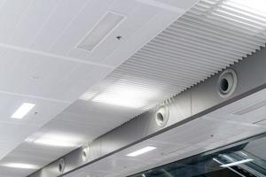 tak monterad kassett typ luft balsam och modern lampa ljus på vit tak. kanal luft balsam för Hem eller kontor foto